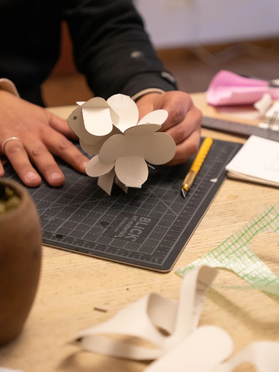 Manos arman un prototipo de papel sobre una base de corte